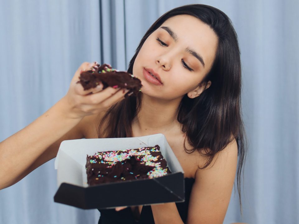 Chica comiendo pastel con las manos